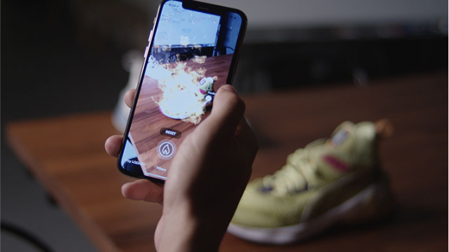 Phone displays an augmented reality filter applied to a shoe in the background.